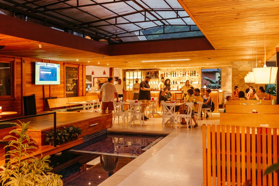Interior de um bar de restaurante movimentado com pessoas desfrutando de uma noite quente.
